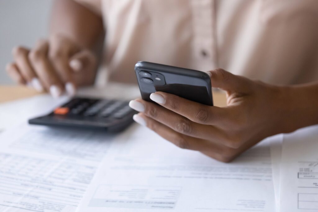 A woman surrounded by paper and holding a calculator, learning about how loans work.